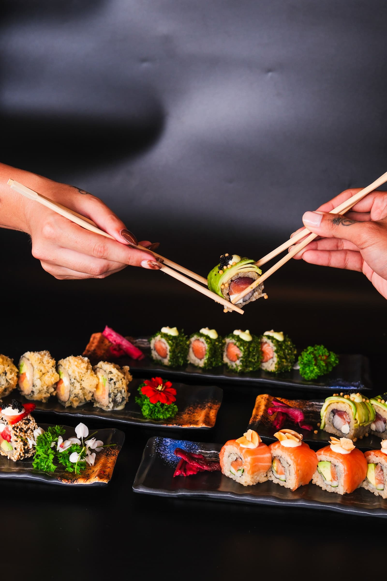 Sharing sushi rolls with chopsticks