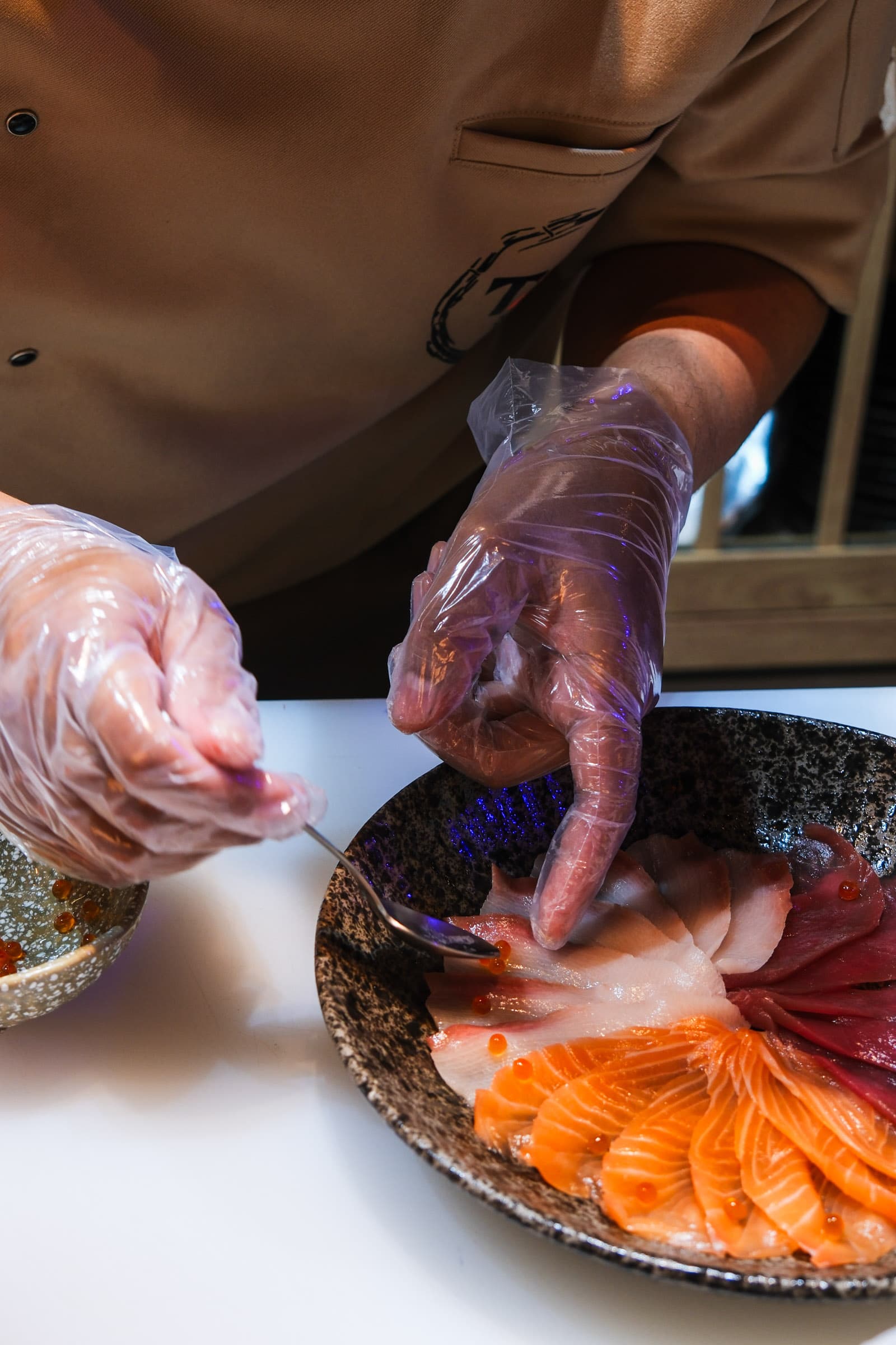 Adding ikura to a sashimi platter
