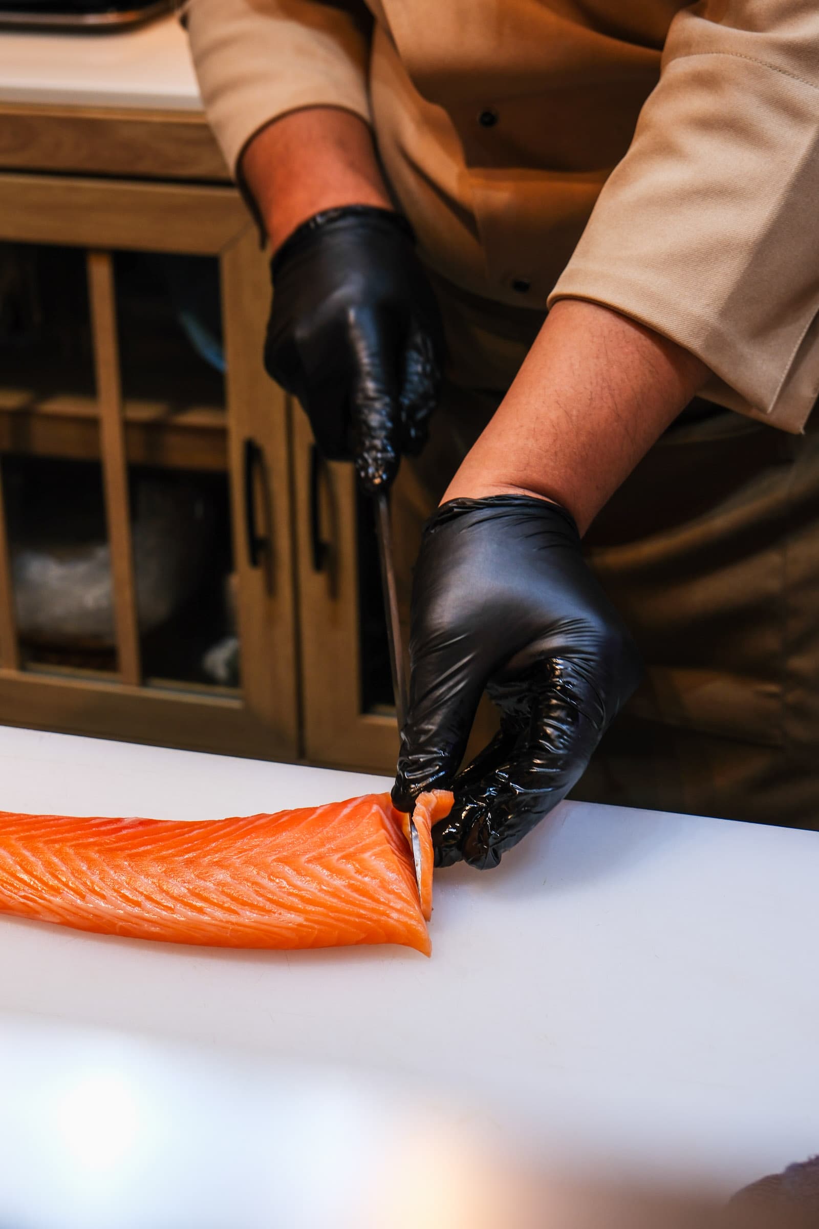 Chef slicing fresh salmon fillet